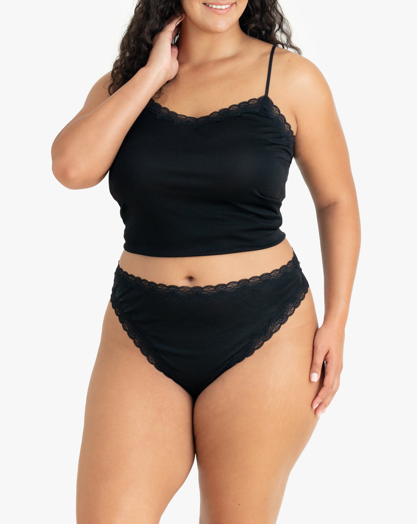 Model wearing Uwila Warrior Soft Silks Thong Underwear in Tap Shoe Black on White Background