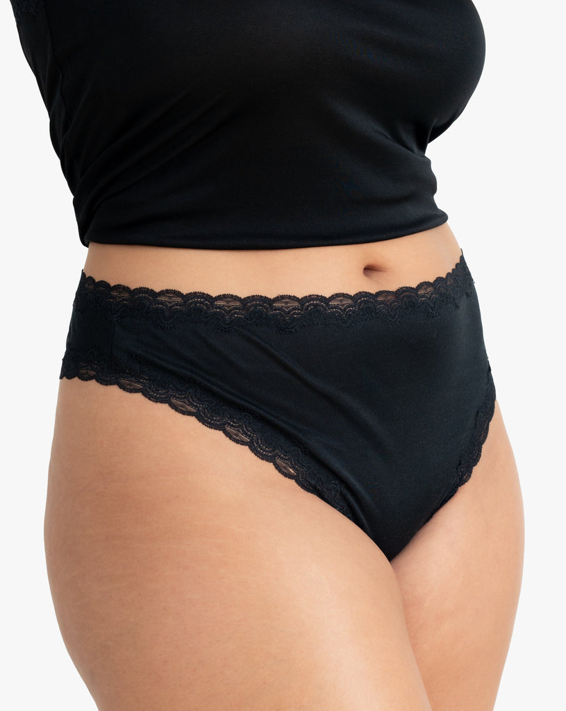 Model wearing Uwila Warrior Soft Silks Thong Underwear in Tap Shoe Black on White Background