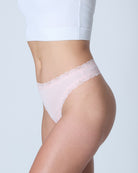 Model wearing Uwila Warrior Soft Silks Thong Underwear in Rose Quartz on White Background