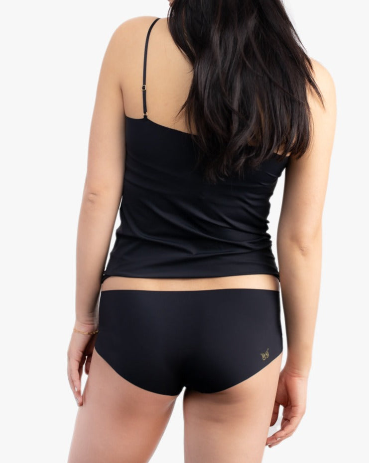 A woman wearing a tap shoe black soft seamless underwear briefs and cami set with lace details.