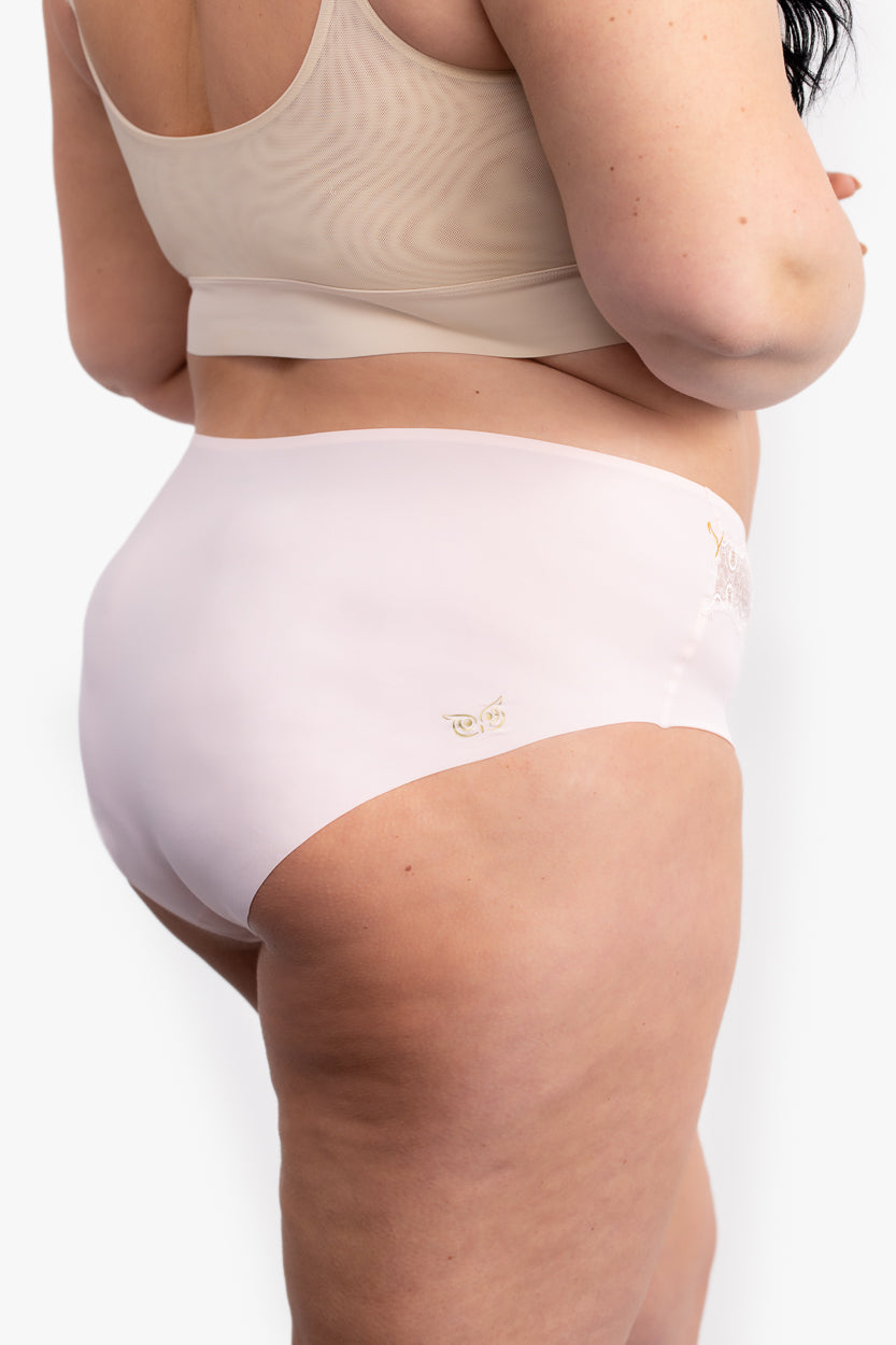 A pair of rose quartz soft seamless briefs with lace detailing white background.