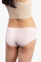 A pair of rose quartz soft seamless briefs with lace detailing white background.