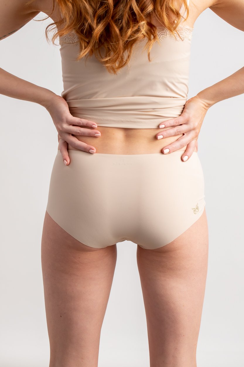 A woman wearing a smoke grey seamless underwear briefs and cami set with lace details.