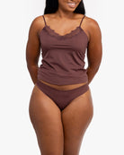 A woman wearing a chocolate soft seamless thong underwear on white background.