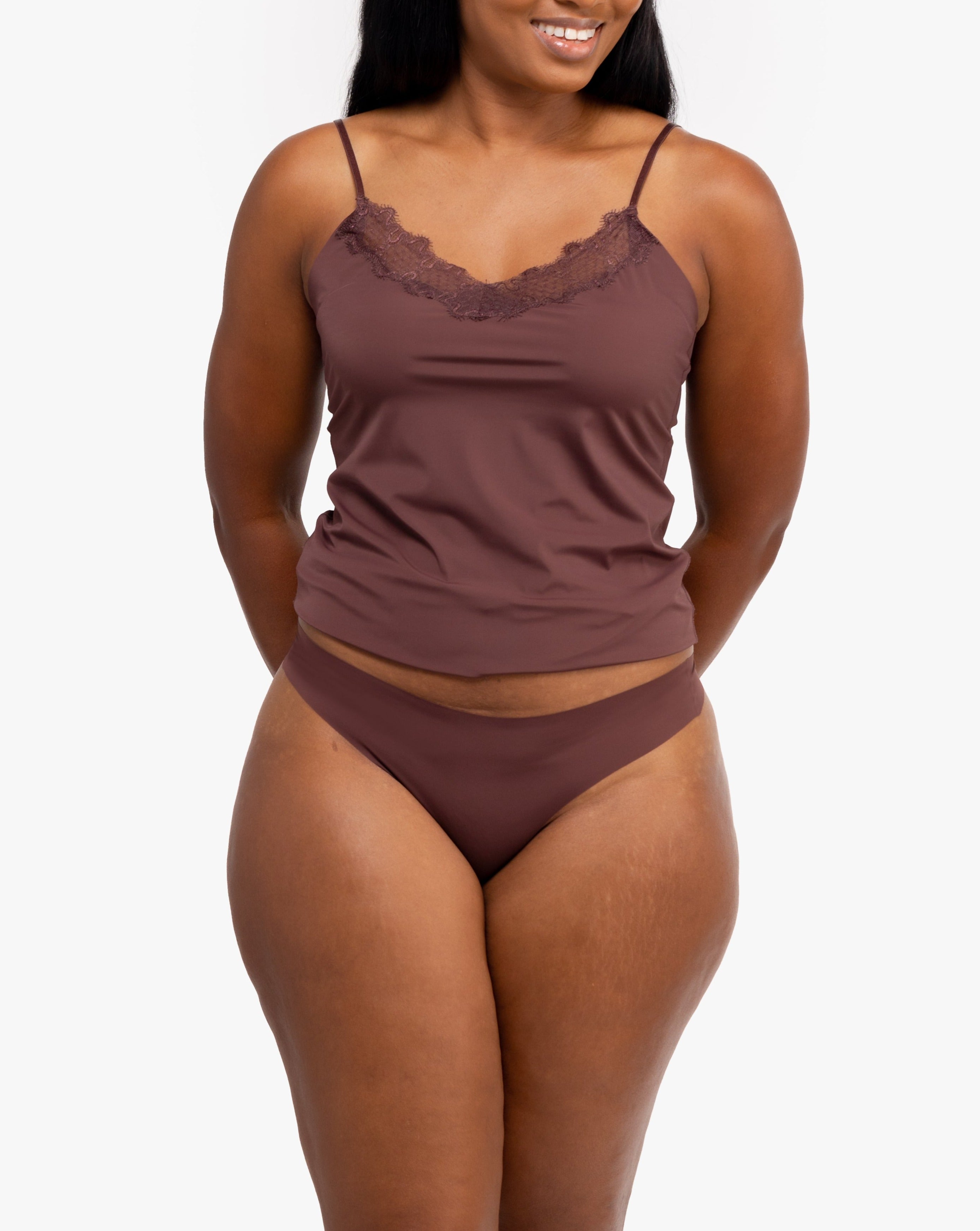 A woman wearing a chocolate soft seamless thong underwear on white background.