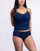 Woman wearing a Dress blue soft seamless lace-trimmed camisole against white background.