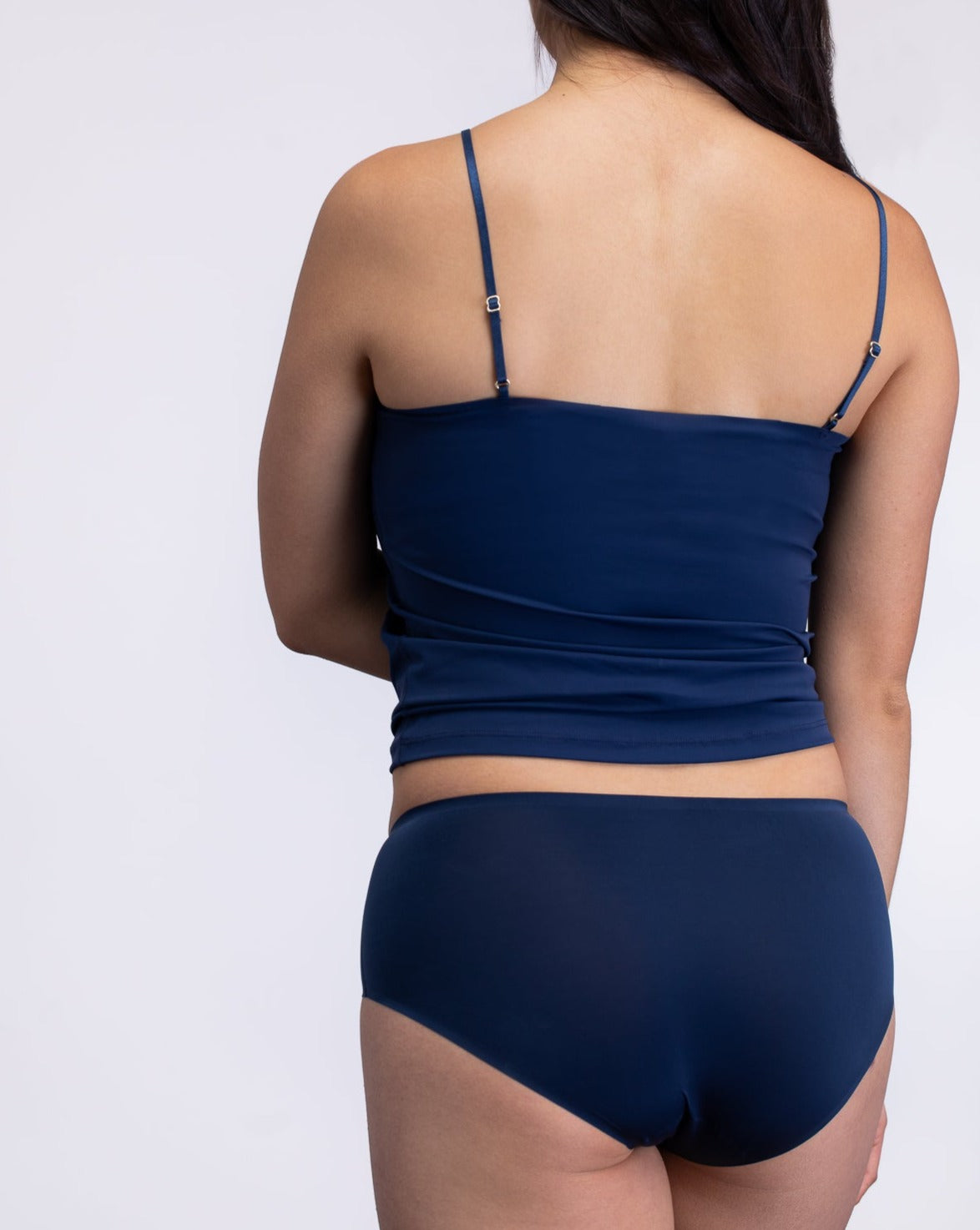 Woman wearing a Dress blue soft seamless lace-trimmed camisole against white background.