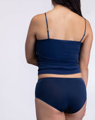 Woman wearing a Dress blue soft seamless lace-trimmed camisole against white background.